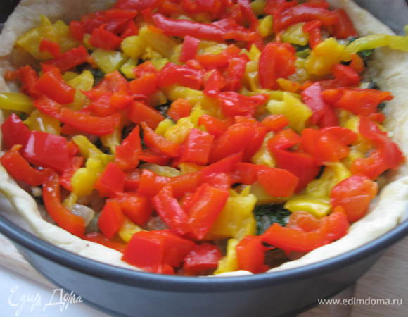 Духовку разогреть до 200 градусов, круглую форму диаметром 24 см. промазать оливковым маслом и застелить  бумагой для запекания. Выпекать тесто без начинки 15 минут. Потом остудить.
Поместить на тесто обжаренный лук  со шпинатом и щавелем. Сверху – желтый и красный перец, пассированные помидоры.
