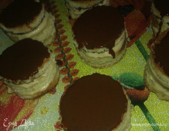 Затем фруктовый крем нанести поверх белковой прослойки. Чайная ложка с горкой  крема плюс еще чуть-чуть - получается идеально!

Уложить наши кружочки с кремом друг на друга: бисквит-пропитка-белковая прослойка-крем-бисквит-пропитка-белковая прослойка-крем.

Далее достать из холодильника оставшиеся кружочки и положить их ганашем вниз, т.е. «крем на крем».

Полить пирожные сверху ганашем и убрать в холодильник. 