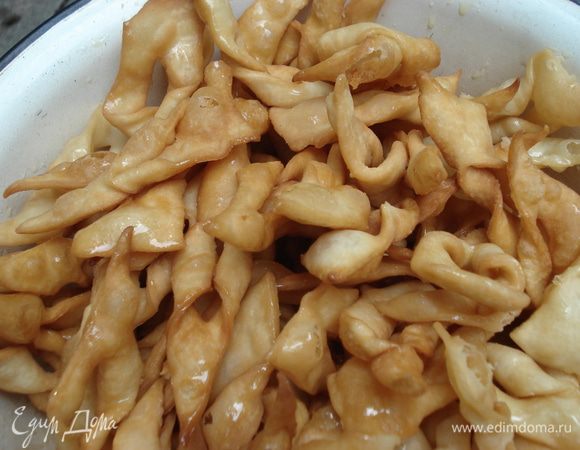 Хворост обжариваем во фритюре, затем выкладываем на бумажные полотенца для удаления излишнего масла, после этого складываем хворост в миску.Топим сливочное масло, в него добавляем мед, хорошо перемешиваем, а затем поливаем этим сиропом хворост.
Вот и все. Приятного аппетита!