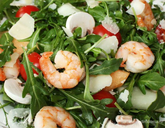 На двух тарелках распределите руколу, томаты, грибы и дыню, перемешайте. Выложите сверху горячие креветки, посыпьте пармезаном и полейте заправкой. Не забудьте бокал белого вина! Приятного аппетита!