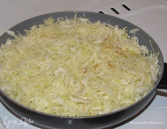 Капусту мелко нашинковать. В сковороде нагреть 1 ст. л растительного масла, положить капусту и жарить 5-7 минут. Затем добавить пол стакана воды и тушить до готовности 6-8 минут. Переложить в миску.
