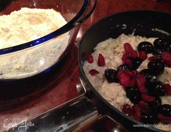 В миске залить хлопья кипятком и отставить в сторону. 
В отдельной миске взбить масло с сахаром до пышности. По одному добавить яйца, каждый раз очень хорошо взбивая. В масляную смесь всыпать пряности и добавить овсянку (к тому времени она уже впитает всю жидкость). Хорошо перемешать. Отдельно смешать сухие составляющие и добавить их к овсяно-масляной смеси. Туда же добавить натёртое на тёрке яблоко и сухофрукты. Перемешать все с помощью лопатки. 