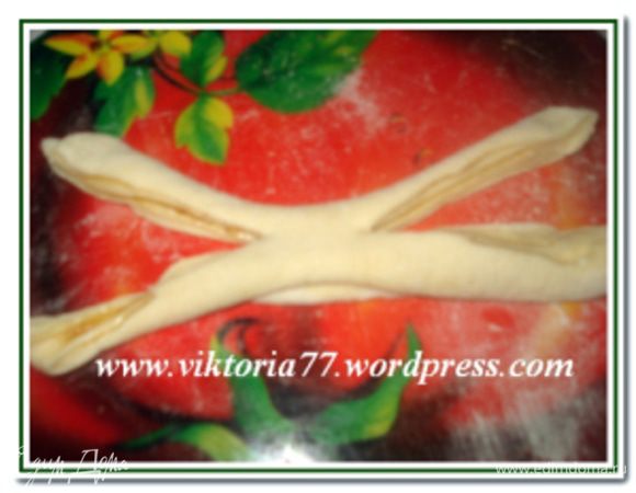 Раскатать из теста прямоугольник (по желанию смазать маслом и посыпать сахаром и корицей). Скатать рулетиком. У рулета сделать два сквозных продольных разреза, не дорезая до середины 1-2 см.