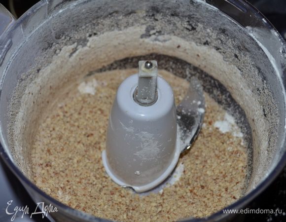  В кухонном комбайне  ножами  порубить орехи в несколько пульсов, смешать  с крахмалом.