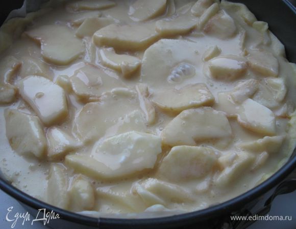 Раскатать тесто. Выложить тесто в форму, сформировав бортики. Сверху разложить яблочные лепестки. Залить форму с тестом и яблоками кремом.
