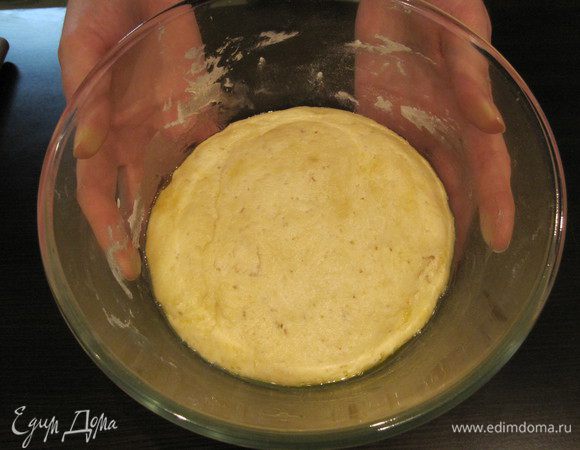 Тесто увеличилось в объеме, теперь можно его раскатать.
Стол надо присыпать мукой. Раскатываем тонкое тесто.
На противень выкладываем лист бумаги для выпечки, смазываем растительным маслом. Перекладываем тесто на противень.