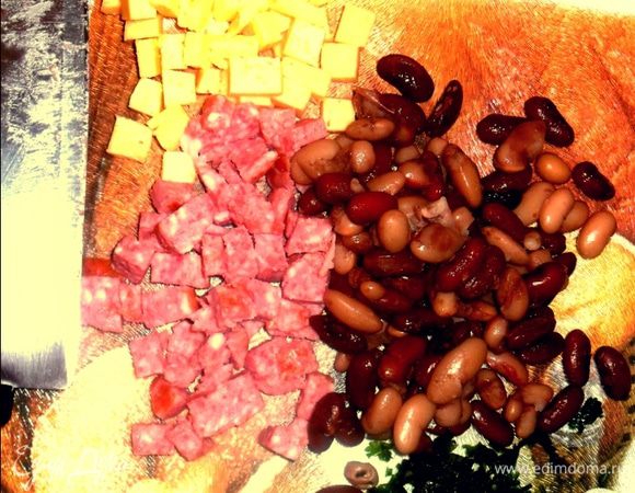 Сыр, колбасу нарезаем кубиками. Мелко нарезаем зелень