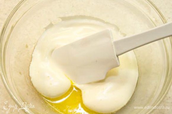 Масло должно быть жидким, но не горячим (просто теплым). Берем несколько ложек яичной массы и смешиваем с маслом методом складывания, то есть, вращая спатулой снизу вверх, как бы зачерпывая массу и заворачивая ее.