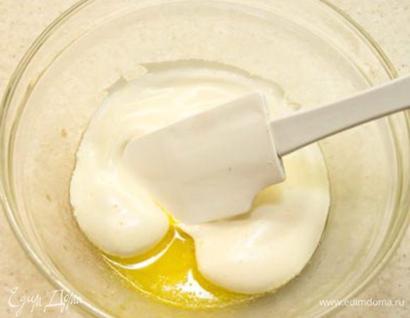 Масло должно быть жидким, но не горячим (просто теплым). Берем несколько ложек яичной массы и смешиваем с маслом методом складывания, то есть, вращая спатулой снизу вверх, как бы зачерпывая массу и заворачивая ее.