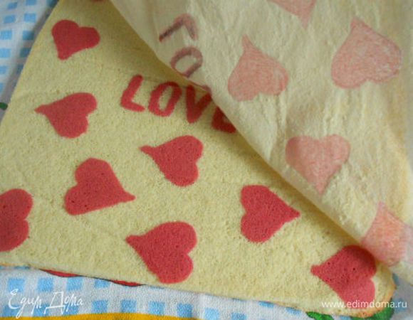 Готовый корж переложить с противня на чистое кухонное полотенце,  слегка смочить водой пергамент и аккуратно удалить его. Осторожно перевернуть корж рисунком вниз и с помощью полотенца скрутить его в рулет.