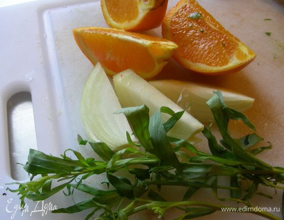 Режем крупно апельсин и лук. Закладываем их во внутреннность курицы, добавив пару веточек эстрагона. Курицу солим, перчим по вкусу. 
