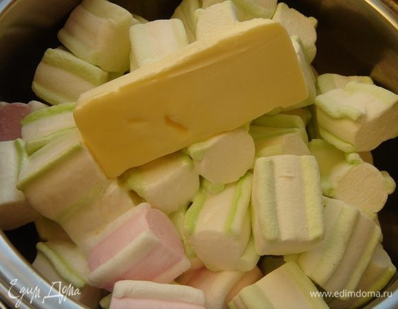 В кастрюлю сложить маршмеллоу и сливочное масло, залить горячей воды и поставить кастрюлю на средний огонь. Разломать шоколад на маленькие дольки.