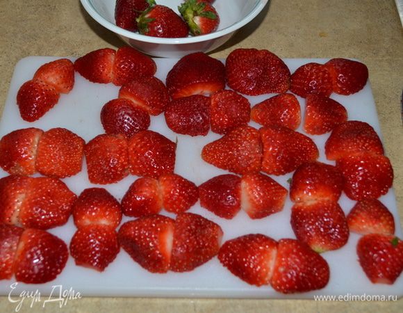 Клубнику порезать на половинки,можно оставить несколько цельных ягод для украшения сверху торта.