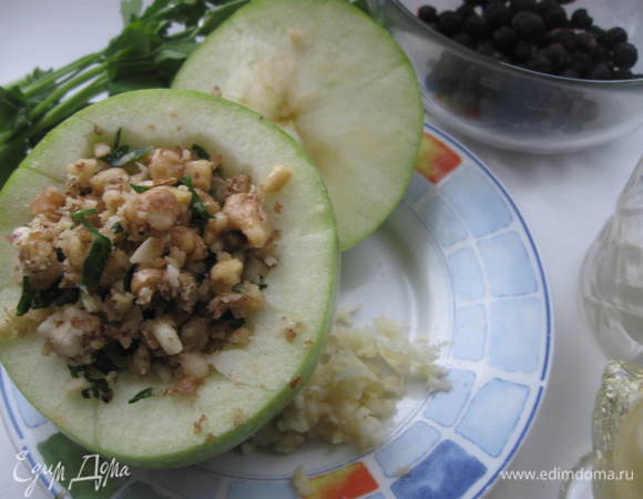 Яблоко помыть, срезать крышечку, из основной части вынуть частично мякоть, семечки.
2 зубчика чеснока, соль, измельченную петрушку размять в ступке.
Наполнить этой смесью яблоко, закрыть крышечкой.
