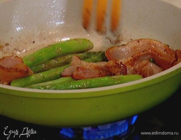 Разогреть сковороду, выложить бекон, добавить спаржу и все вместе обжарить.