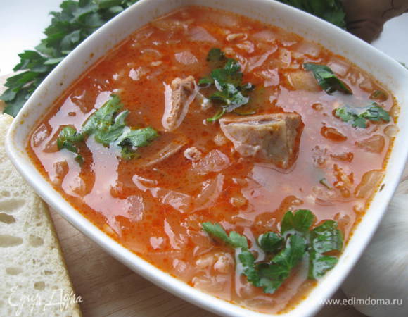 Поставить бульон на огонь, дать закипеть. Опустить лук. Огонь убавить. Через 15 минут запустить  рис, нарезанное мясо, сливу с ткемали, хмели-сунели.
За 5 минут до готовности запустить томатную пасту, чеснок с зеленью.
Нарезать  оставшуюся петрушку, кинзу, Можно подать отдельно, можно запустить в суп.
По консистенции харчо  должно получиться довольно густое – что-то среднее между первым блюдом и вторым.  Суп должен настояться минут 15.
