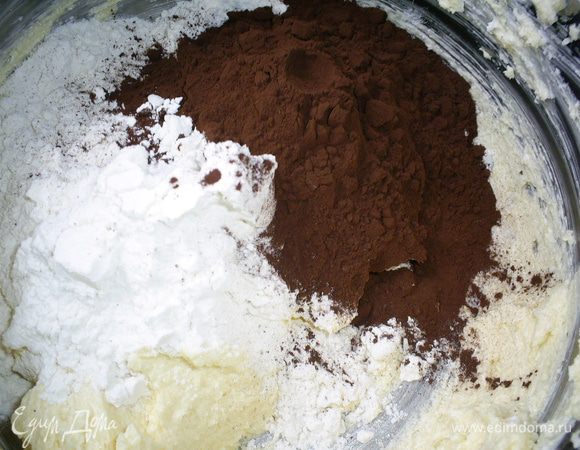 Во вторую просеем 150 г муки, какао и отправляем оставшуюся масляную массу.