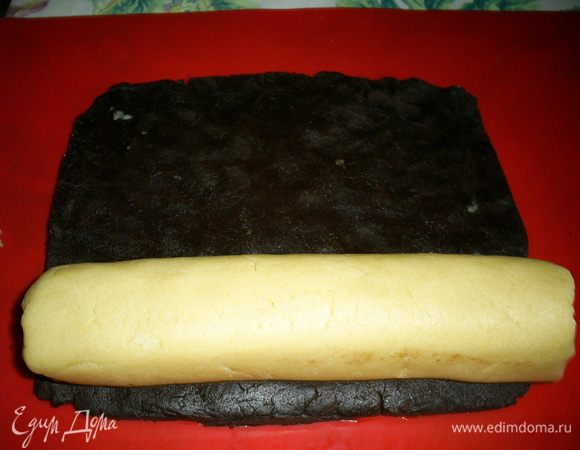 Теперь кладем колбаску на край шоколадного пласта и аккуратно сворачиваем тугой рулет.