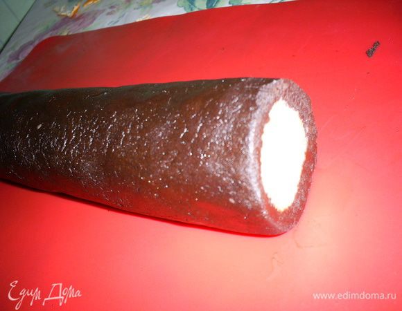 Полученный рулет покатаем по столу, чтоб избавиться от пространства между слоями теста, плотно завернем в пищевую пленку и отправим в холодильник минимум на час, можно и на ночь, у меня он там "зимовал" примерно 5 часов.