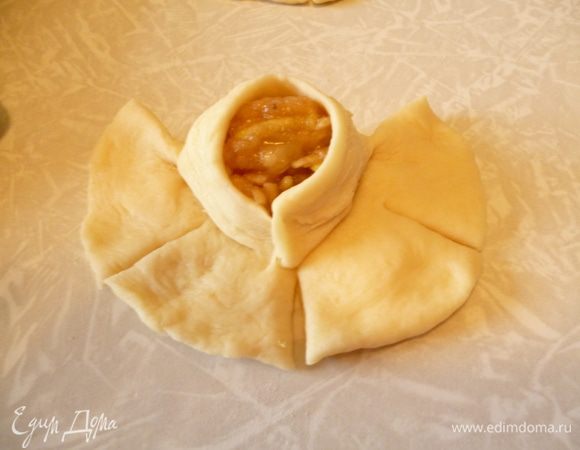 Берем один лепесток,слегка растягиваем за края и закрепляем вокруг начинки.