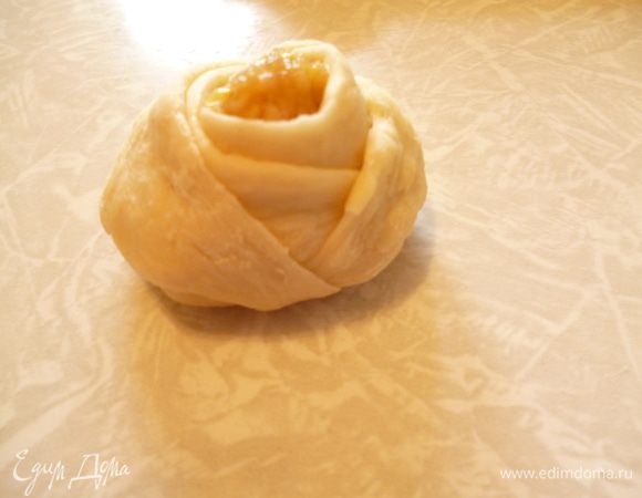 И обводим вокруг бутона.Краешки прячем под низ,таким образом розочка не будет разворачиваться во время расстойки и выпечки.