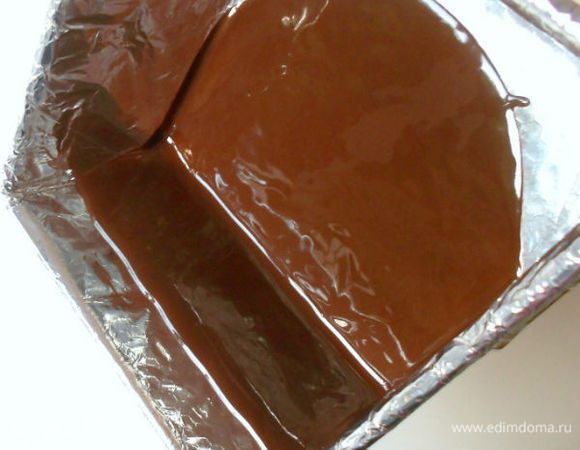 Шоколад поломать на кусочки, положить в миску и расплавить на водяной бане.
Жидкий шоколад вылить на дно  прямо на фольгу. Осторожно наклонить форму, чтобы шоколад стекал на один из бортиков формы до нужной отметки. 