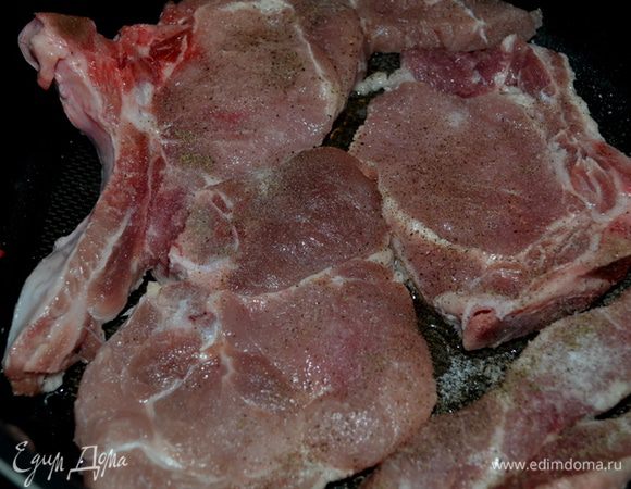 Разогреть олив.масло на сковороде.Обжарить свиные отбивные 2-3 мин. каждую сторону. 