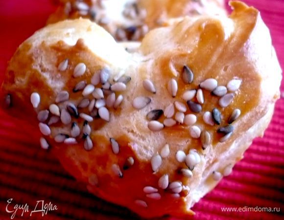 Предлагаю Вам также попробовать вот такие сырные эклеры. Готовятся они очень просто, можно совсем отказаться от начинки, они имеют очень приятный сырный вкус! Попробуйте! Для 30 таких сердечек мы ставим на огонь сотейник, растапливаем 60 грамм масла с 125 г молока и щепоткой соли, вводим сразу 110 грамм муки и хорошо перемешиваем, пока масса не начнет оставлять беловатый след на дне сотейника, снимаем с огня и даем слегка остыть. Затем вводим в массу по одному яйцу, даем каждому яйцу полностью смешаться с тестом. Добавляем 75 грамм тертого твердого сыра типа Пармезан и хорошо перемешиваем. Духовку разогреваем до 200 градусов. Начиняем тестом кондитерский мешок и выкладываем на противень , застеленный пекарской бумагой, по чуть-чуть теста. Смазываем каждое сердечко желтком и посыпаем нашими любимыми семечками или толчеными орешками, ставим в духовку на 15-20 минут. Приятного аппетита!!!