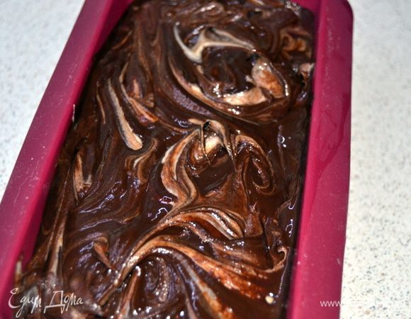 Затем выложить оставшееся тесто и вылить остатки шоколада.У меня получилось на самом деле много шоколада,спокойно можно обойтись и 50 граммами.И еще Поль говорит,что выливать шоколад нужно в тесто сразу после замеса,слегка перемешать,а затем уже выливать в форму.Поскольку у меня сразу получилось много шоколада,мне не захотелось выливать его в общую массу,дабы не получить однородный шоколадный кекс.