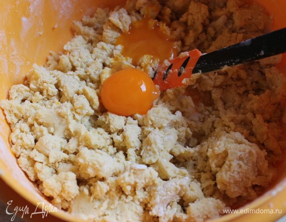 Просеянную муку с разрыхлителем перетереть с маргарином.
Добавить желтки, соль, сахар.
Вылить опару и оставшееся молоко.