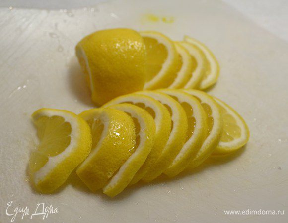 Лимон нарезать дольками, оставить 1/4 часть для сока.