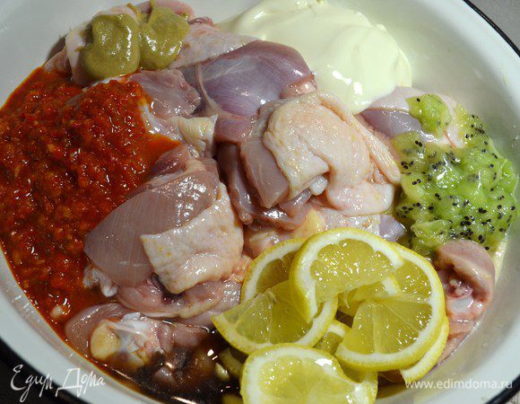 Мясо уложить в миску (кастрюлю), где оно будет мариноваться. Добавить в маринад для шашлыка аджику, кетчуп, соевый соус, нарезанные лимоны, киви, майонез, горчицу. Хорошо перемешать.