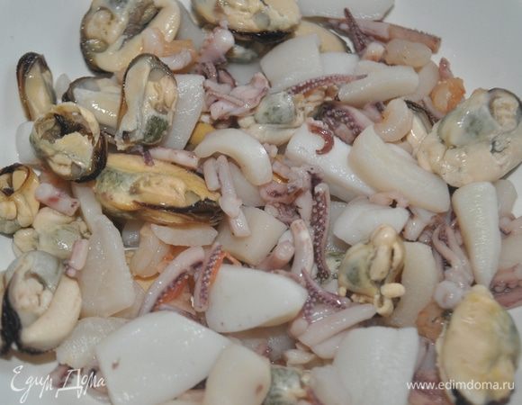 В кипящую воду положить морепродукты, посолить и варить 7 - 8 минут, откинуть на дуршлак, остудить.