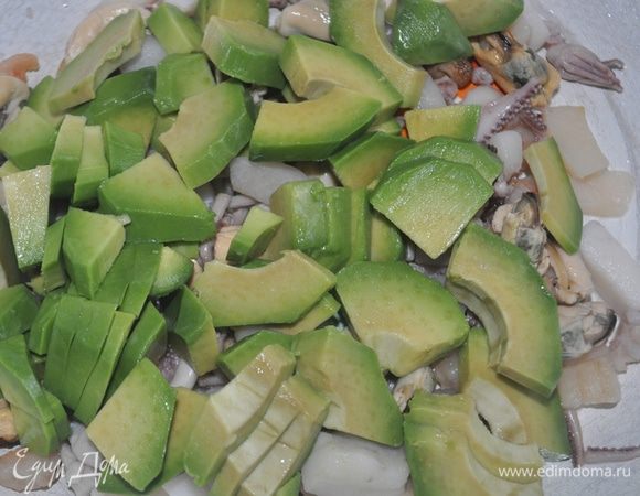 Авокадо очистить от косточки и кожуры,тонко нарезать дольками,добавить к морепроуктам вместе с лимонным соком и оставшимся маслом,посолить по вкусу,перемешат