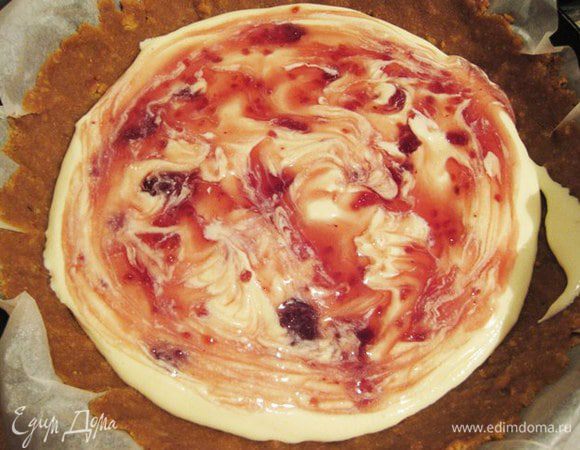 В яично-творожную смесь добавить растопленный шоколад, сметану, манку и хорошо перемешать, можно миксером на низкой скорости или блендером. (Проверьте на сладость) Выложить на основу половину начинки и аккуратно распределить варенье.