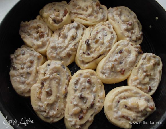 Свернуть тесто вдоль короткого края. Теперь разрезать получившийся рулет на 12 кусочков. Переложить "улитки" в форму для выпечки, смазать 2 ст. л. растопленного масла ( у меня были остатки яйца, поэтому я смазала им) и оставить подходить на 10 минут.