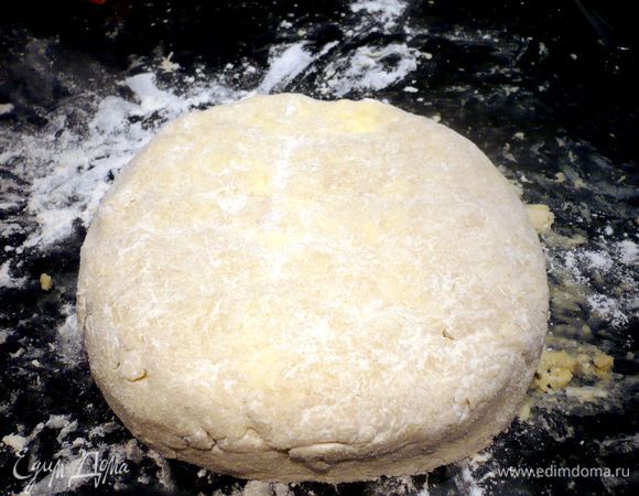 Вымешиваем тесто как можно энергичнее (я кончиками пальцев нажимала на кусочки масла, чтобы оно быстрее разошлось) до однородного состояния, можно подсыпать совсем немножко муки. Вот такое тесто у нас получилось, надавливаем на колобок немножко, чтобы он превратился в лепешку. 