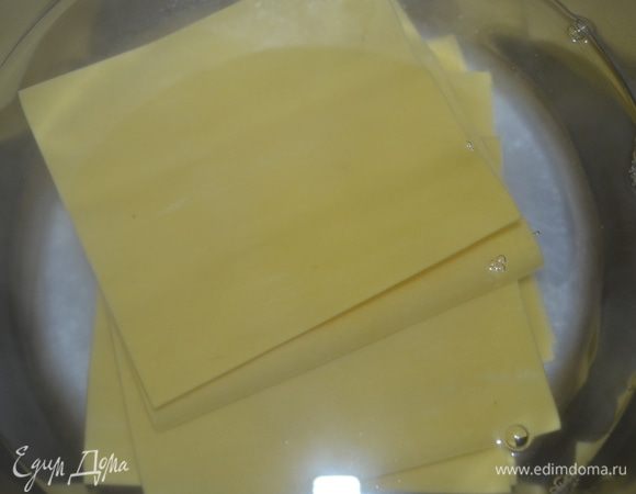 Листы лазаньи залить кипятком и дать им постоять 2 минуты. Такой способ их подготовки был написан на упаковке. Если у вас написано, что надо отварить их заранее - то отварите! Но сырыми (сухими) в такую лазанью их класть нельзя. 