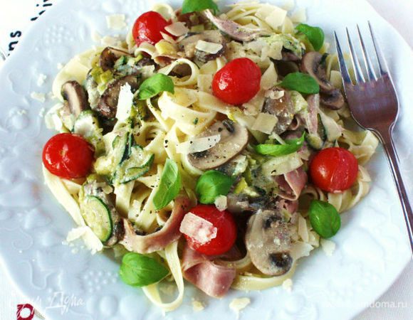 Выложить на тарелку феттучине, сверху овощную смесь с соусом. Украсить базиликом и приправить чёрным свежемолотым перцем, посыпать пармезаном. 