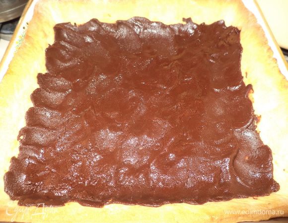 Распределить шоколад по тесту, заходя и на бортики, и немного охладить.
