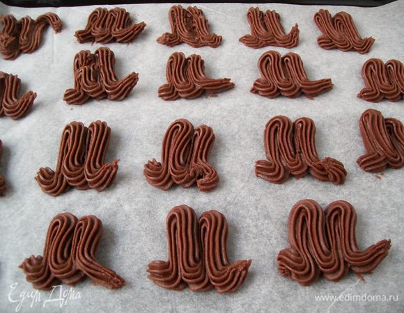 Тесто переложить в кондитерский мешок с насадкой  "звезда" и отсадить на пергаментную бумагу ( бумагу не смазывать -печенье содержит и так много масла)
Необходимо нарисовать букву  "М", но между краями не должно быть зазоров.

Выпекать 10-12 минут  в разогретой духовке до 180 градусов. 
