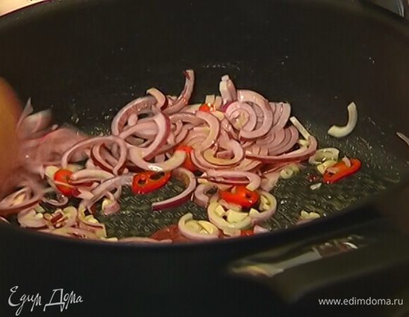 Приготовить соус: разогреть в сковороде оливковое масло и слегка обжарить чеснок и чили на небольшом огне, затем добавить лук и обжаривать все вместе еще несколько минут.