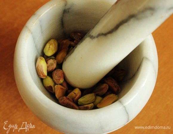 Фисташки мелко порубить или истолочь в ступке в крупную крошку.