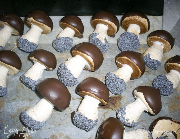 Тем временем растапливаем черный шоколад. Вынимаем застывшие грибки из холодильника, обмакиваем в шоколад шляпку и аккуратно выкладываем грибки на пергамент или пищевую пленку или файл. Снова отправляем в холодильник  грибки застывать и уже предвкушаем, как будем удивлять близких и радовать ребятишек.