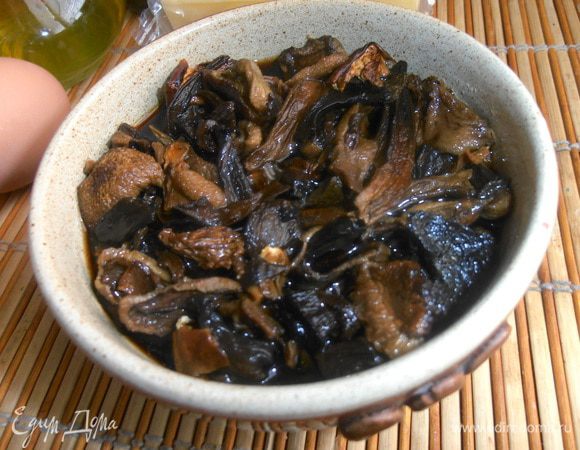 Через 2-3 часа сливаем тёмную жидкость (можно использовать в суп!) и отжимаем грибочки.