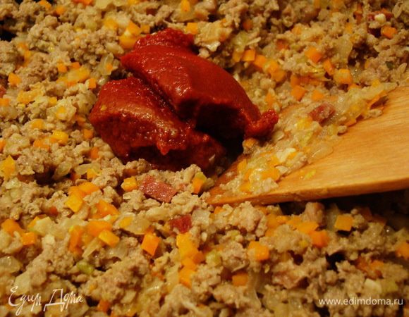 Добавляем томатную пасту, перемешиваем, обжариваем