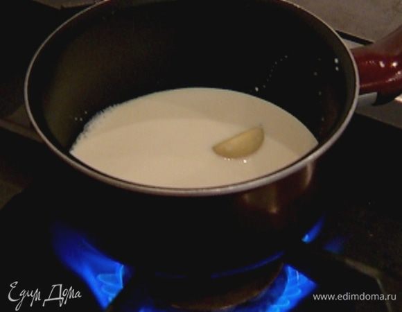 Приготовить соус: молоко и сливки влить в небольшую кастрюлю и, добавив чеснок, довести до кипения, затем чеснок вынуть.