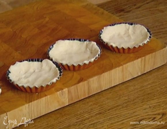 Тесто разрезать на 4 части и выложить в небольшие формы, равномерно распределив по дну и бортикам.