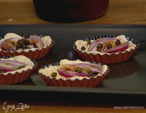 В каждую форму выложить по 1 ст. ложке сырно-яичного соуса, по дольке лука и понемногу каперсов.