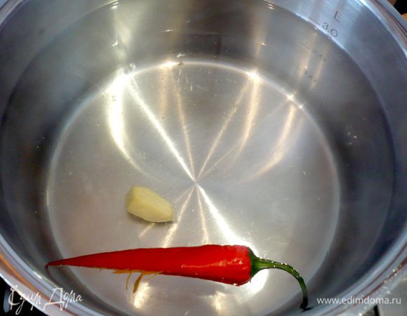 В кастрюле доводим до кипения воду, бросаем в нее очищенный от семян перец-чили и почищенный имбирь, а затем спагетти. Варим до готовности около 10 минут.